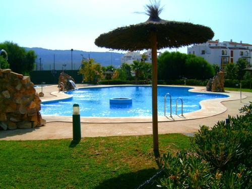 una gran piscina con una sombrilla en un patio en Apartamento Sol & Orilla, en Zahara de los Atunes