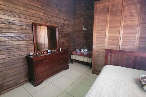 a bedroom with a bed and a dresser and a mirror at “La Choza” Beach Cabin en el Poblado de Boquerón in Cabo Rojo