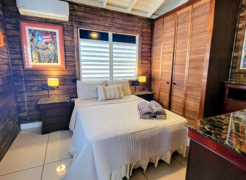 a bedroom with a white bed and a window at “La Choza” Beach Cabin en el Poblado de Boquerón in Cabo Rojo