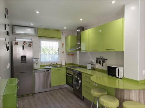 a kitchen with lime green cabinets and a dishwasher at Chalet Antonio&Ewa in La Eliana