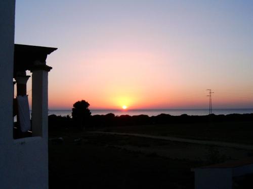 サアラ・デ・ロス・アトゥネスにあるApartamento Sol & Orillaの家から海に沈む夕日