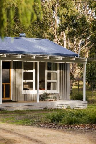 a small house with a blue roof at Lawrence creek cottage Bruny Island in Great Bay