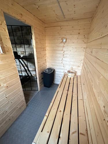 a wooden bench in a sauna with a trash can at Eddies Lodge & Spa 3 bedroom cottage in Dungiven
