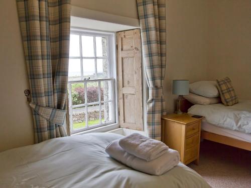 a bedroom with a bed and a window at Drummuie House in Golspie