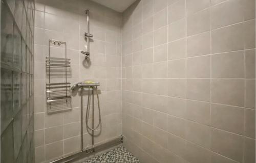 łazienka z prysznicem wyłożona białymi kafelkami. w obiekcie 3 Bedroom Lovely Home In Simlngsdalen w mieście Simlångsdalen