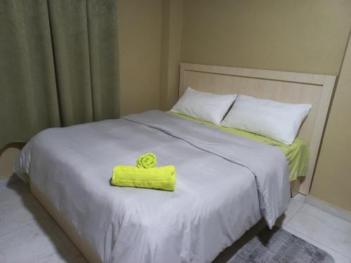 uma cama branca com uma toalha amarela em Klev's apartments em Shkodër