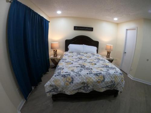 a bedroom with a bed and two tables with lamps at Orlando Vacation Apartment 3919 in Orlando