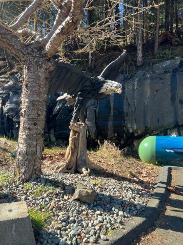 a statue of a bird standing next to a tree at High Point Resort in Quathiaski Cove