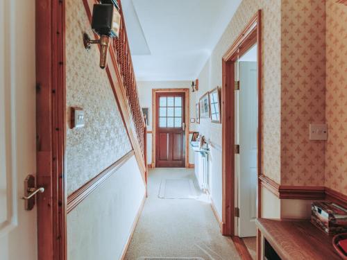 un pasillo de una casa con una puerta y un pasillo en The Beeches en Portinscale