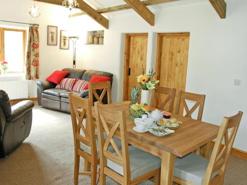 een woonkamer met een houten tafel en stoelen bij The Stables in Bodmin