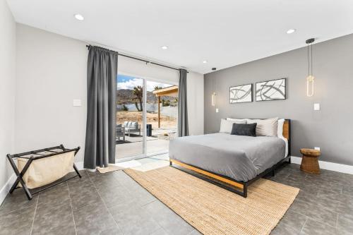 a bedroom with a bed and a large window at Luxury Desert Retreat w Pool & Jacuzzi in Joshua Tree
