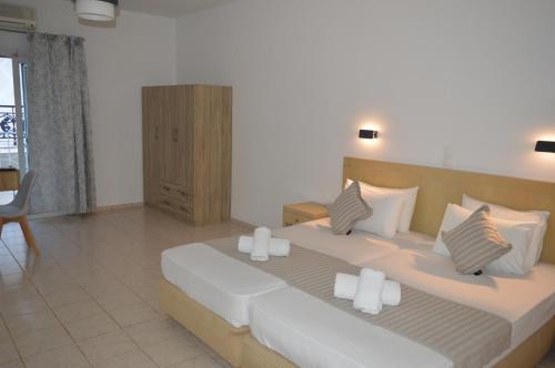 una camera da letto con un grande letto con lenzuola e cuscini bianchi di Junction studios a Città di Skiathos