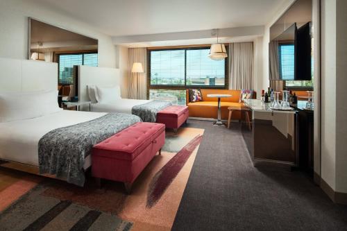 ロサンゼルスにあるSLS ホテル ア ラグジュアリー コレクション ホテル ビバリー ヒルズのベッド2台とデスクが備わるホテルルームです。