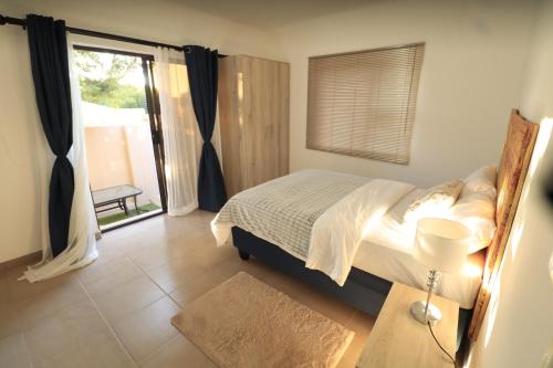 a bedroom with a bed and a large window at Casa Decha in Windhoek