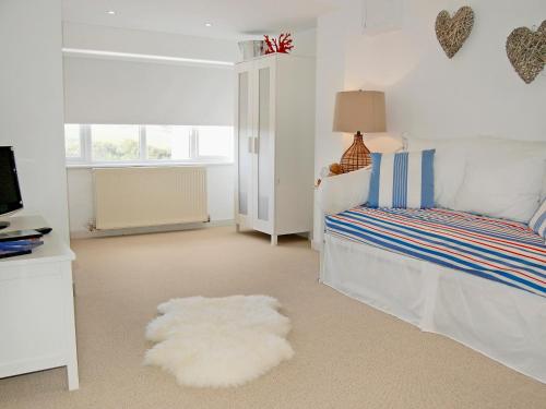a bedroom with a bed and a white rug at The Lookout in Port Isaac