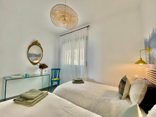 two beds in a white room with a mirror at Coastal Hills in Altea