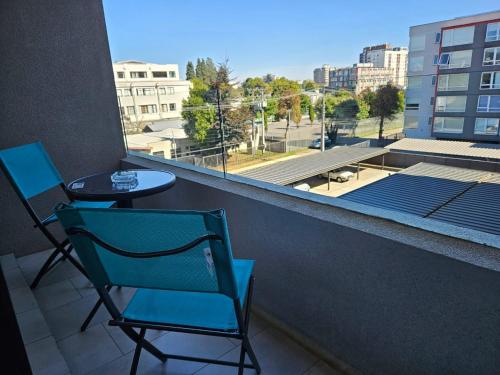 een stoel en een tafel op een balkon met uitzicht bij Apartamentos Bauerle Curitiba in Temuco