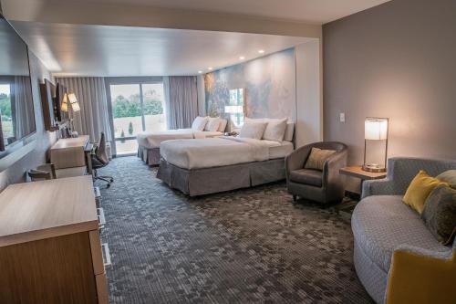 グリーンビルにあるCourtyard by Marriott Greenville Mauldinのベッドとソファ付きの広いホテルルームです。