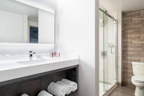 a bathroom with a sink and a mirror and a fireplace at Mystic Marriott Hotel and Spa in Groton