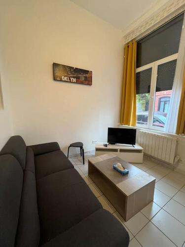 un salon avec un canapé et une table basse dans l'établissement appart cosy 2P- proche métro, Lille à 15 min, à Roubaix