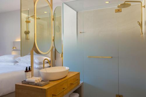 a bathroom with a sink and a glass shower at Caro & Selig, Tegernsee, Autograph Collection in Tegernsee