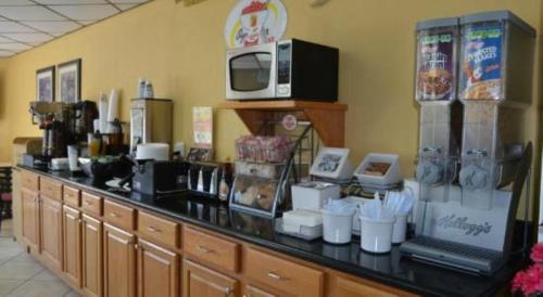 un comptoir dans un restaurant avec un four micro-ondes dans l'établissement Super 8 by Wyndham Clinton, à Clinton