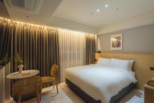 a hotel room with a bed and a table at Asherah Villa d' aqua Hotel in Gimhae