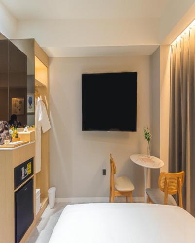 a hotel room with a bed and a table and a tv at Asherah Villa d' aqua Hotel in Gimhae