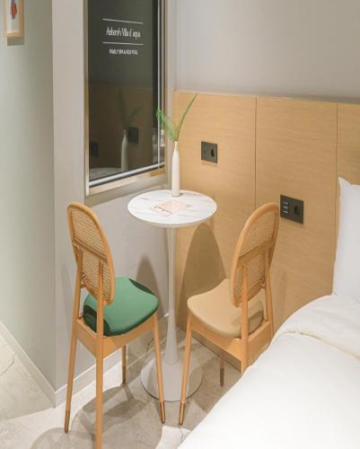 a bedroom with a table and two chairs and a bed at Asherah Villa d' aqua Hotel in Gimhae