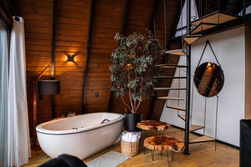 a bath tub in a room with a wooden wall at Altitude 1140 Urubici - Chalés in Urubici