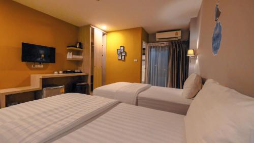 a hotel room with two beds and a tv at Letana Hotel in Bang Phli