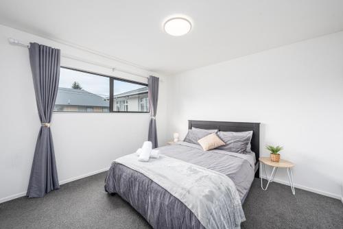 a bedroom with a bed and a window at Newly Built Two Bedroom with Double Garage in Wigram