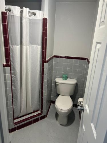 un baño con inodoro y ducha en Broadway Inn Motel, en San Antonio