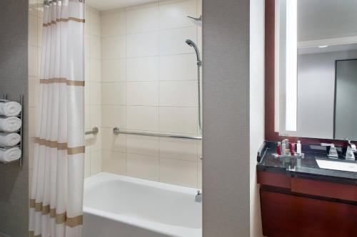 a bathroom with a tub and a shower with a sink at Atlanta Airport Marriott Gateway in Atlanta