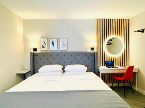 - une chambre avec un lit, un bureau et une chaise rouge dans l'établissement Joes Brand New 2 King Bedrooms Townhome in Canmore, à Canmore
