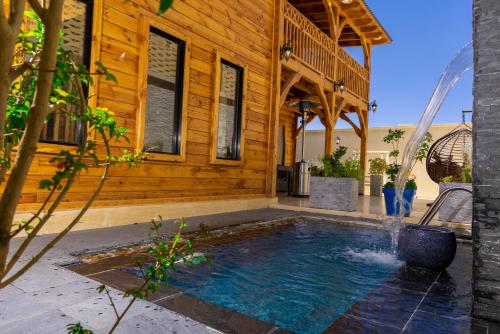 a swimming pool in front of a wooden house at أكواخ غيم ومطر in Al Hada
