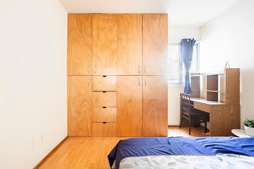 een slaapkamer met een grote houten kast en een bureau bij Habitación en Napoles cerca de WTC in Mexico-Stad