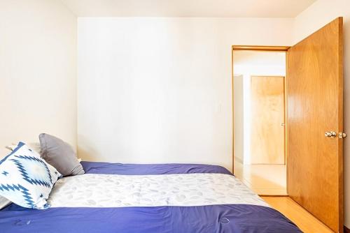 1 dormitorio con 1 cama y puerta de madera en Habitación en Napoles cerca de WTC, en Ciudad de México