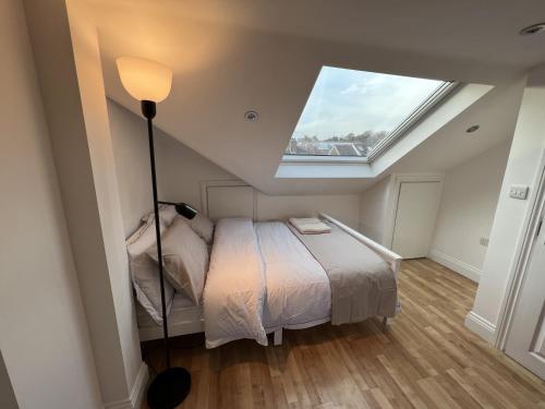 a bedroom with a bed with a skylight at 4 Wharncliffe Drive in Hanwell