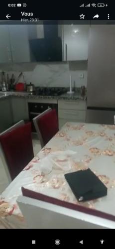 een keuken met een tafel en een laptop bij باهيه بيتش بشاطئ بوزينقه in Bouznika