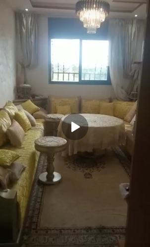 een woonkamer met een tafel en een bank bij باهيه بيتش بشاطئ بوزينقه in Bouznika