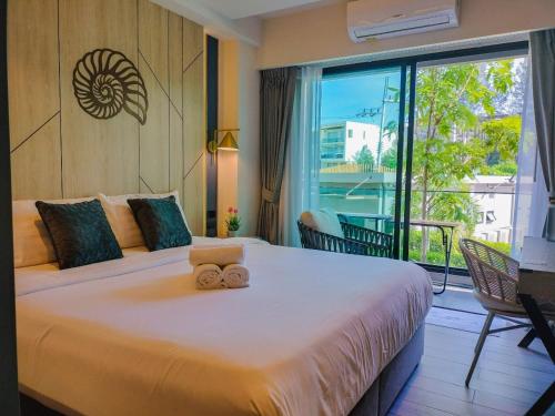 a bedroom with a large bed and a balcony at Carapace Residents Huahin-Khaotao in Khao Tao