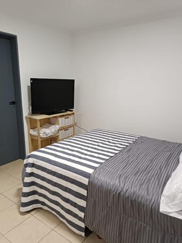 a bedroom with a bed and a flat screen tv at Hermoso departamento en Rio Gallegos in Río Gallegos
