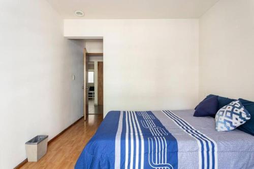 - une chambre dotée d'un lit avec des draps bleus et blancs dans l'établissement Habitación con baño privado, à Mexico