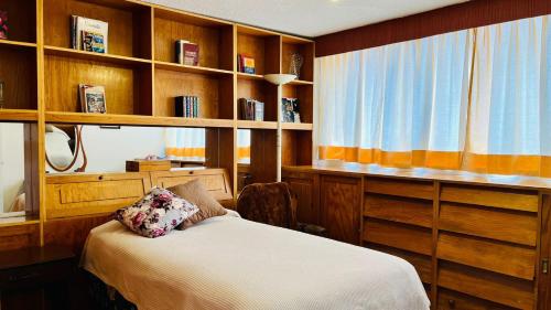 um quarto com uma cama e algumas prateleiras de madeira em Gelati apartment 1Parking 2BR 2BA em Cidade do México