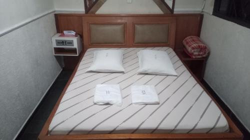 Una cama pequeña con 2 almohadas blancas. en Hotel Malibu (ADULT ONLY) en São Paulo