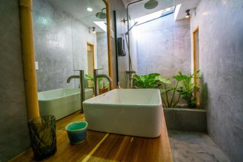 a bathroom with a tub and a sink and a bath tub at Palayan Villa - Villa with views, garden and jacuzzi in El Nido