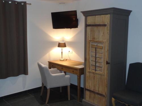 a room with a desk and a chair and a television at B&B Domaine du Vieux Chêne in Stoumont