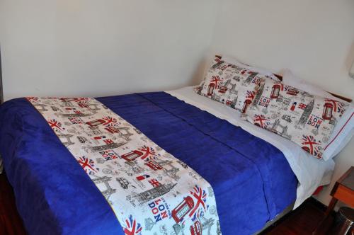 a bed with a blue blanket and pillows on it at Hotel Suite Imperial in Tunja