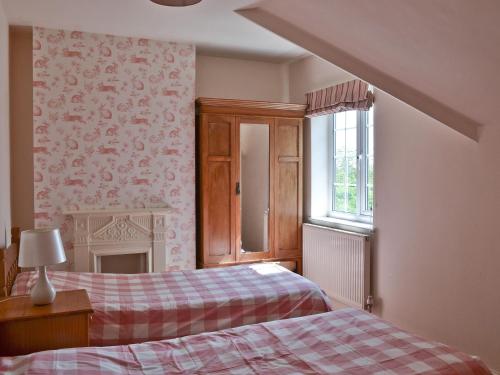 a bedroom with two beds and a window at Barrowswood in Cheddar